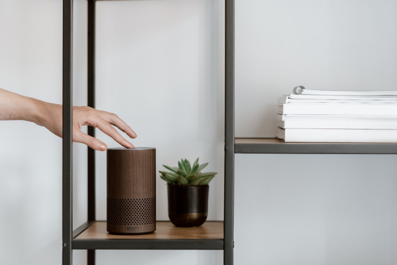 Hand touching a smart speaker