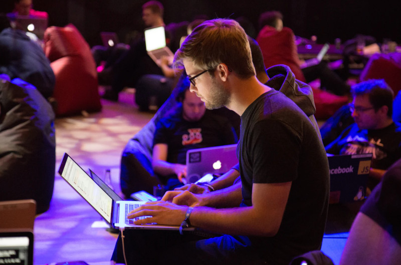 Many people on chairs working on laptops