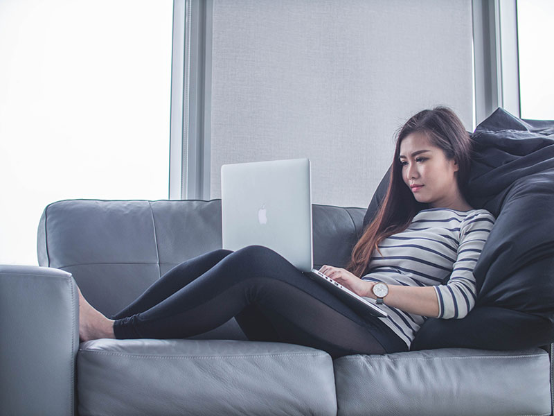 Woman working on laptop on couch